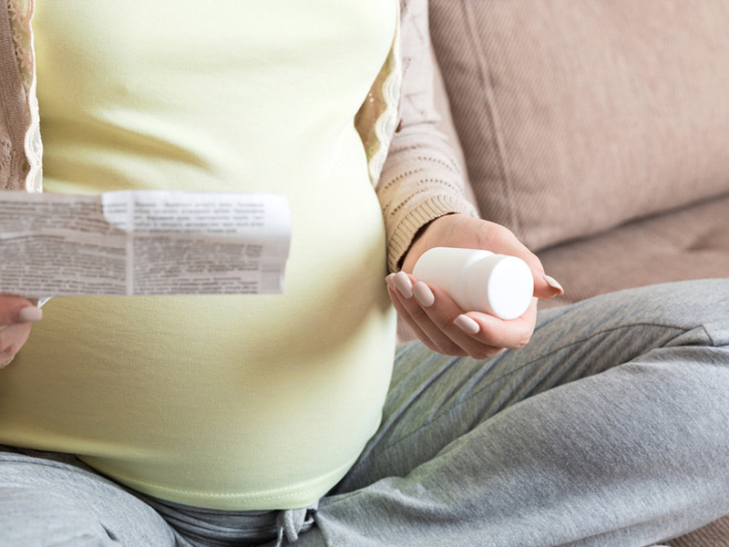 Pregnant woman consulting medication information for safe prenatal care